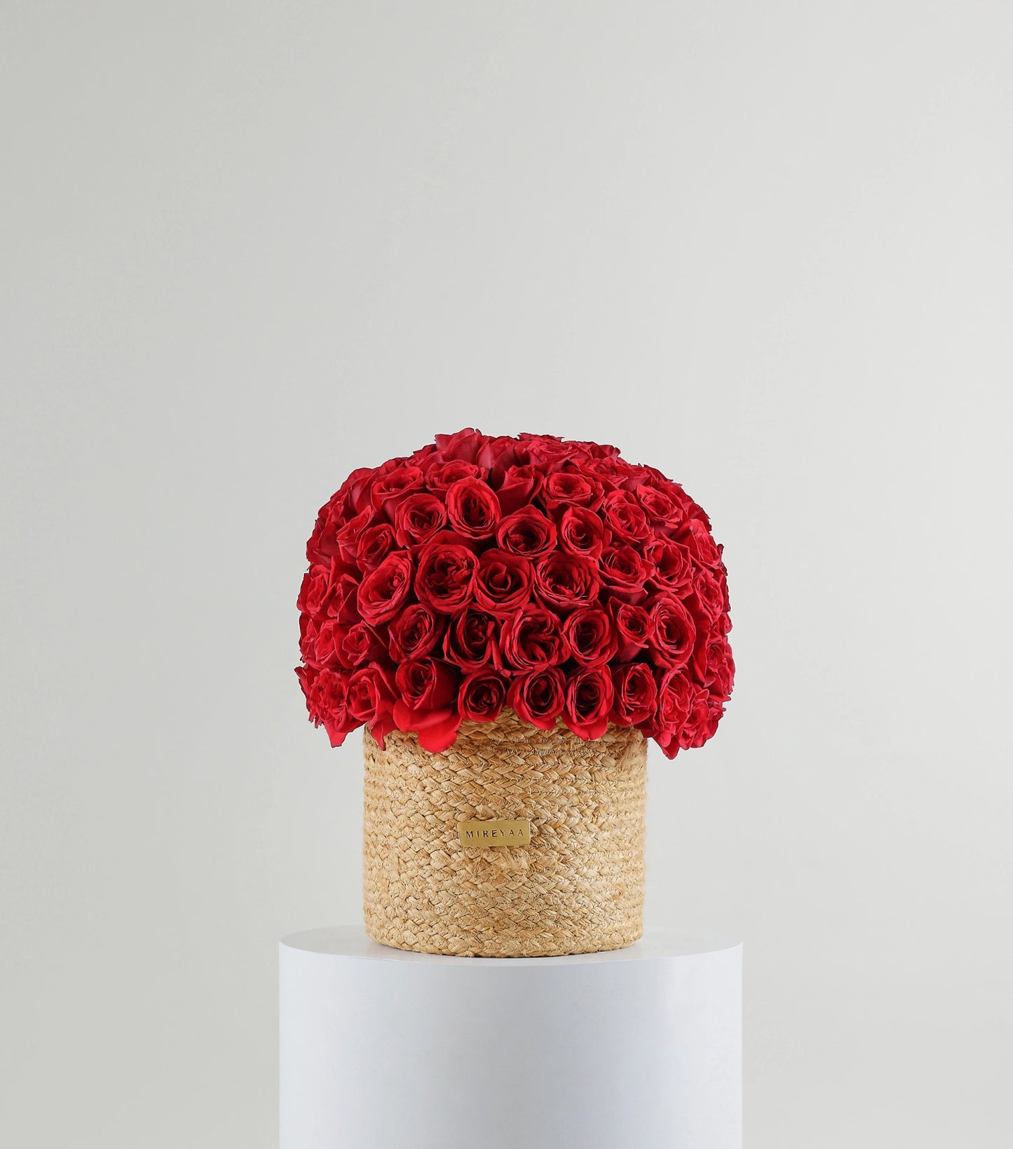 Front view of crimson red roses in a handwoven jute harvest basket — The Crimson Harvest Basket by Mireyaa, Mumbai same-day delivery