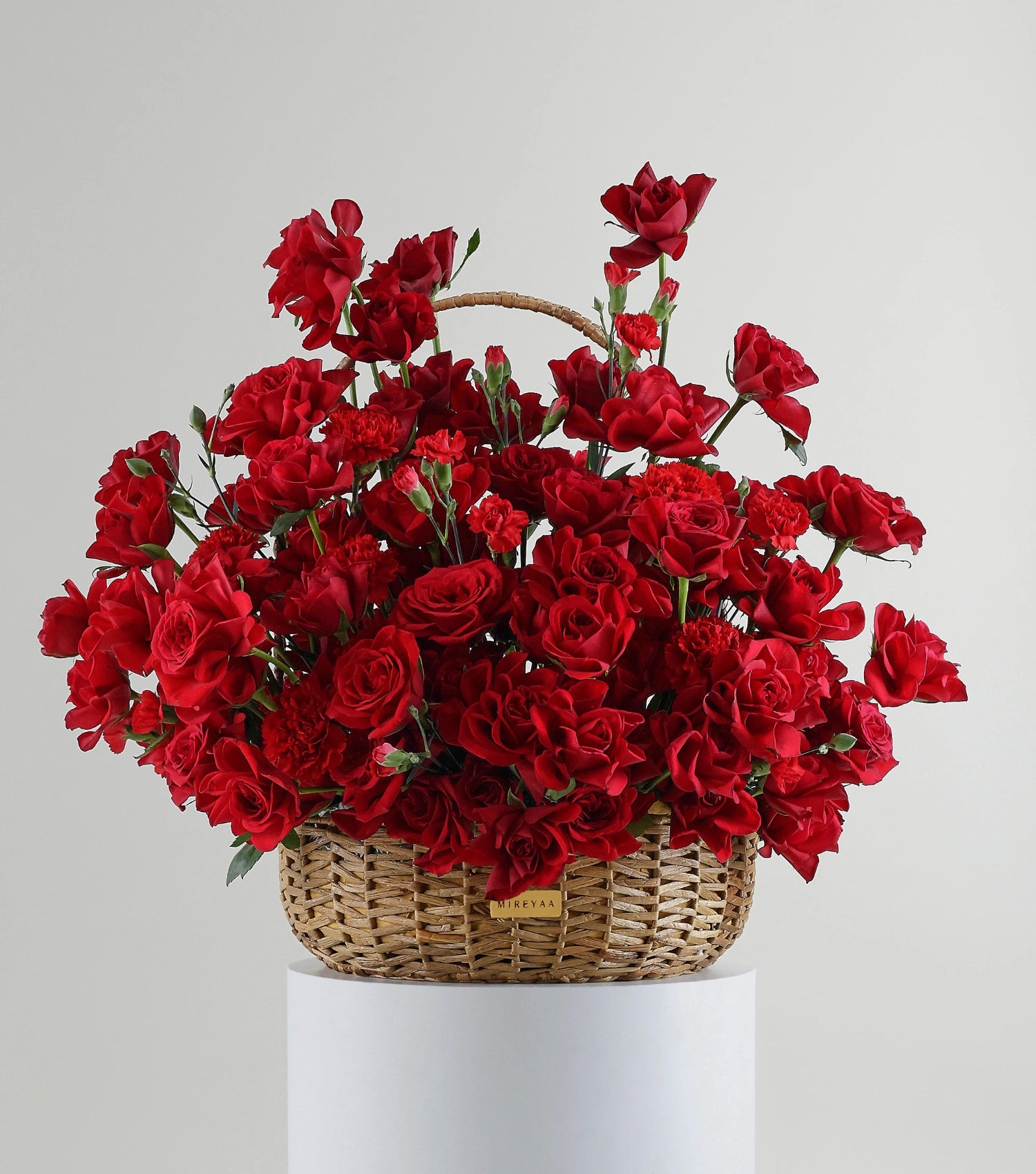 Front view of crimson red roses in a water hyacinth estate basket — The Crimson Petal Estate Basket by Mireyaa, Mumbai same-day delivery