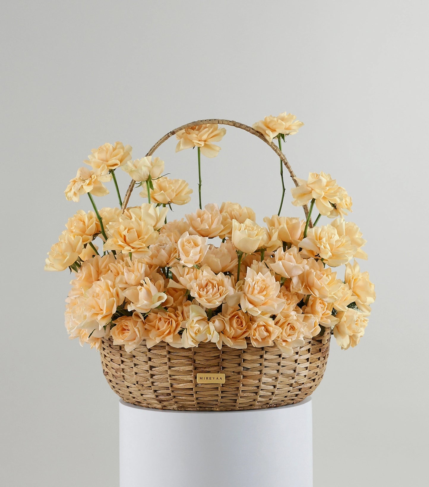 Front view of Grande size apricot roses in a water hyacinth estate basket — The Sculpted Rose Estate Basket by Mireyaa, Mumbai same-day delivery