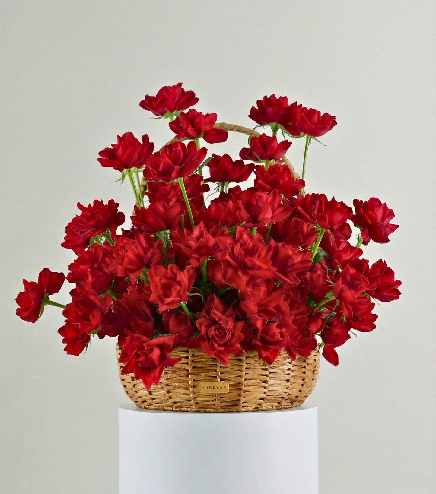 Front view of crimson red roses in a water hyacinth estate basket — The Sculpted Rose Estate Basket by Mireyaa, Mumbai same-day delivery