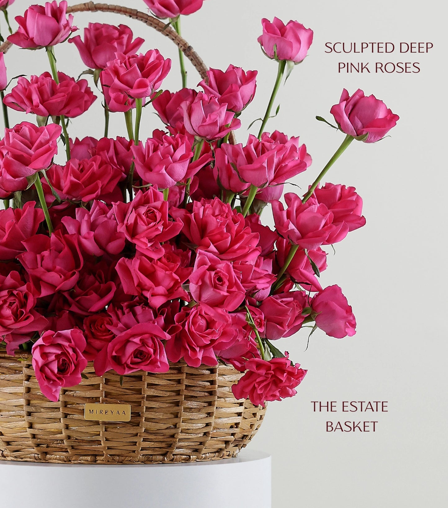 Close-up of deep pink roses in a water hyacinth estate basket — The Sculpted Rose Estate Basket by Mireyaa, Mumbai same-day delivery