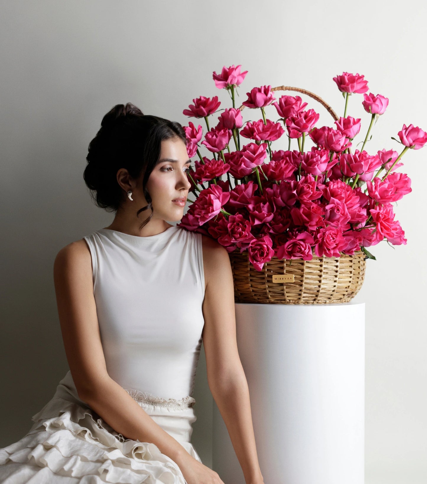 Side view of deep pink roses in a water hyacinth estate basket — The Sculpted Rose Estate Basket by Mireyaa, Mumbai same-day delivery