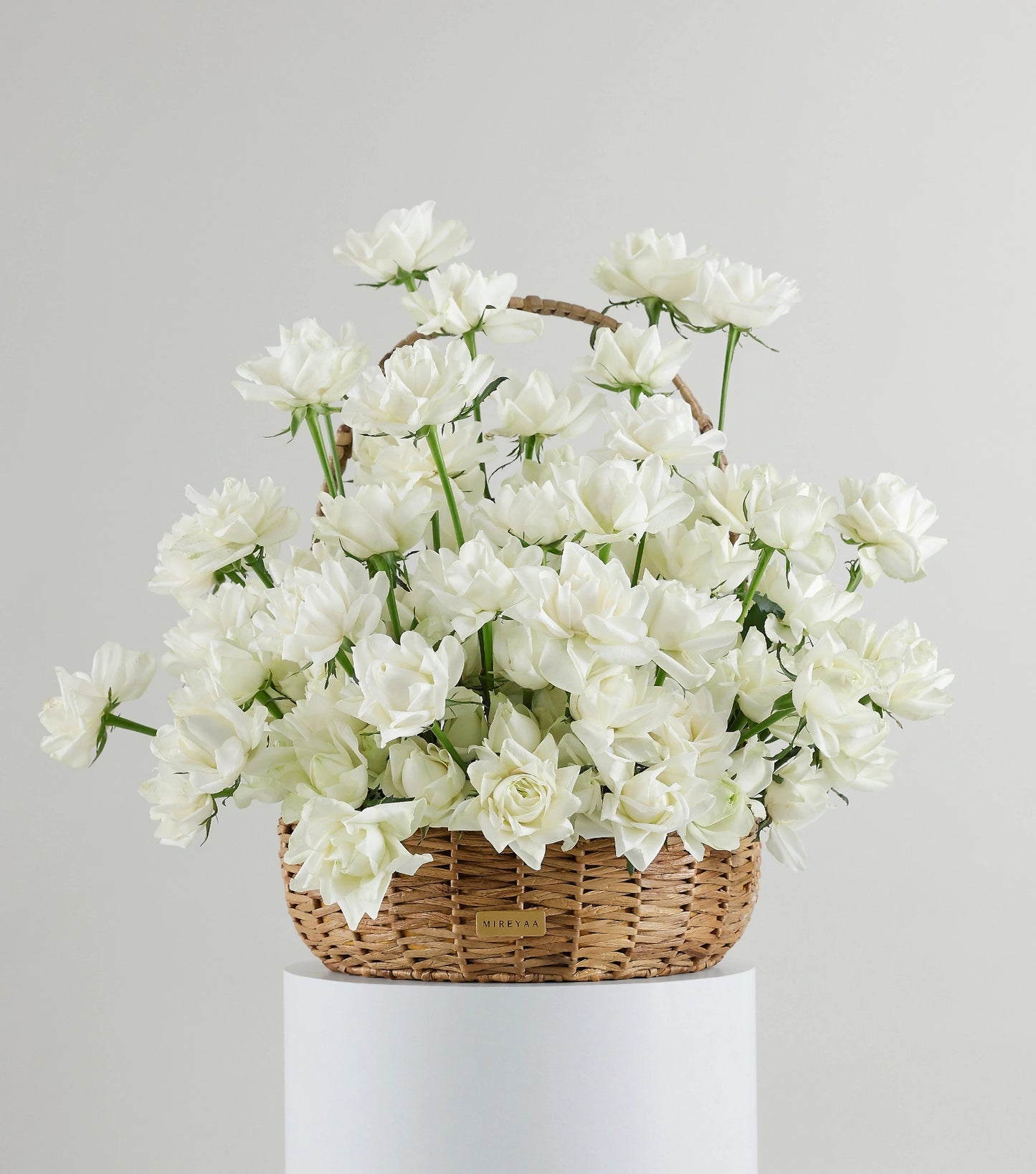 Front view of ivory white roses in a water hyacinth estate basket — The Sculpted Rose Estate Basket by Mireyaa, Mumbai same-day delivery